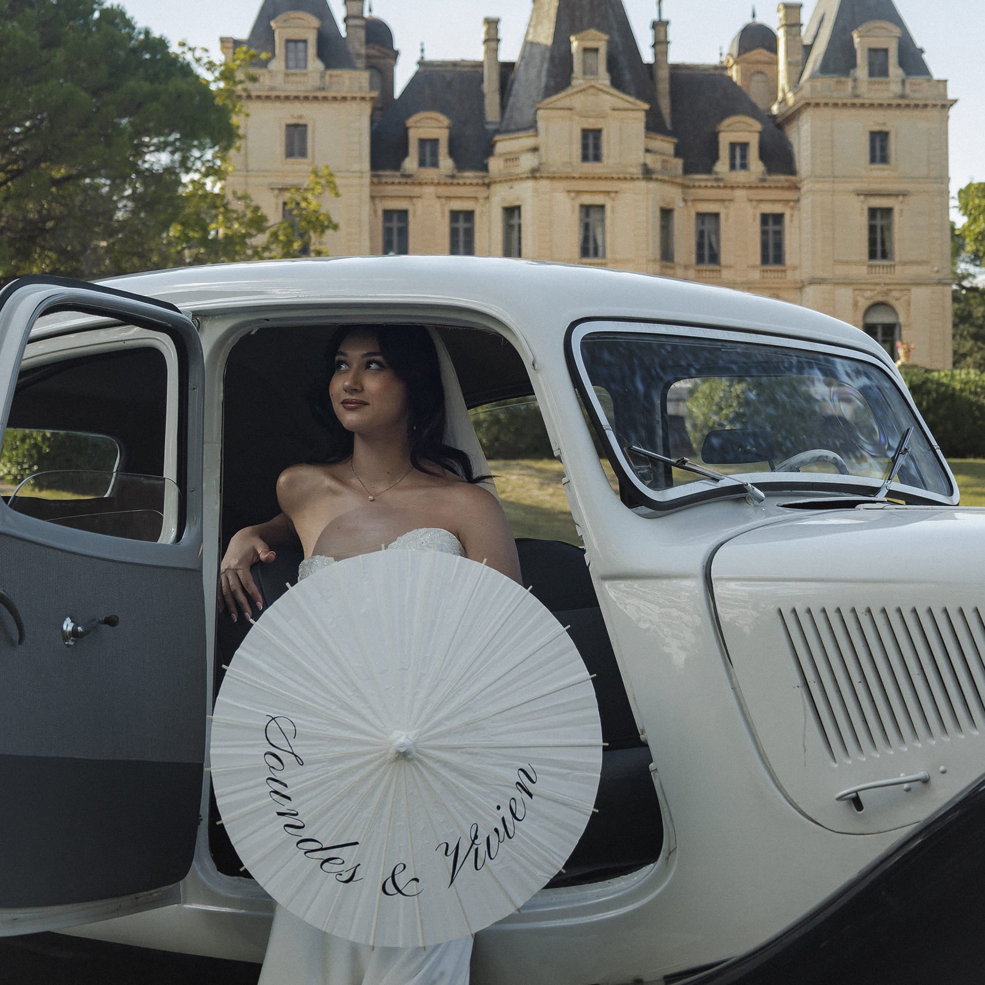 Mariée tenant une ombrelle de mariage personnalisée lors d’une séance photo, accessoire iconique et ultra photogénique.