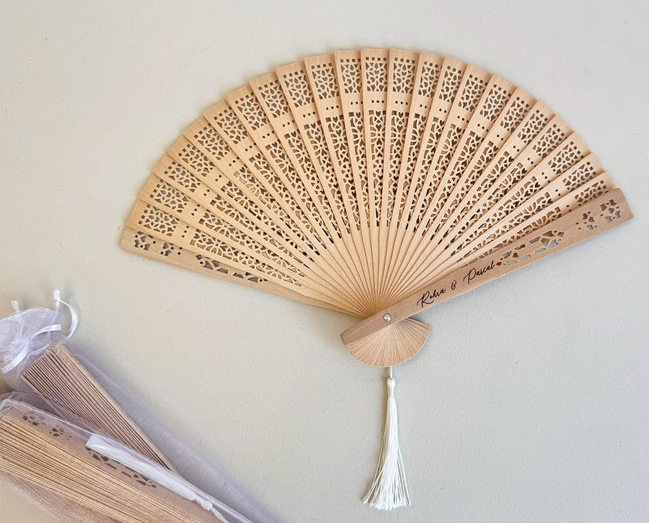 Éventail en papier personnalisé avec pompon, détail raffiné pour invités de mariage.