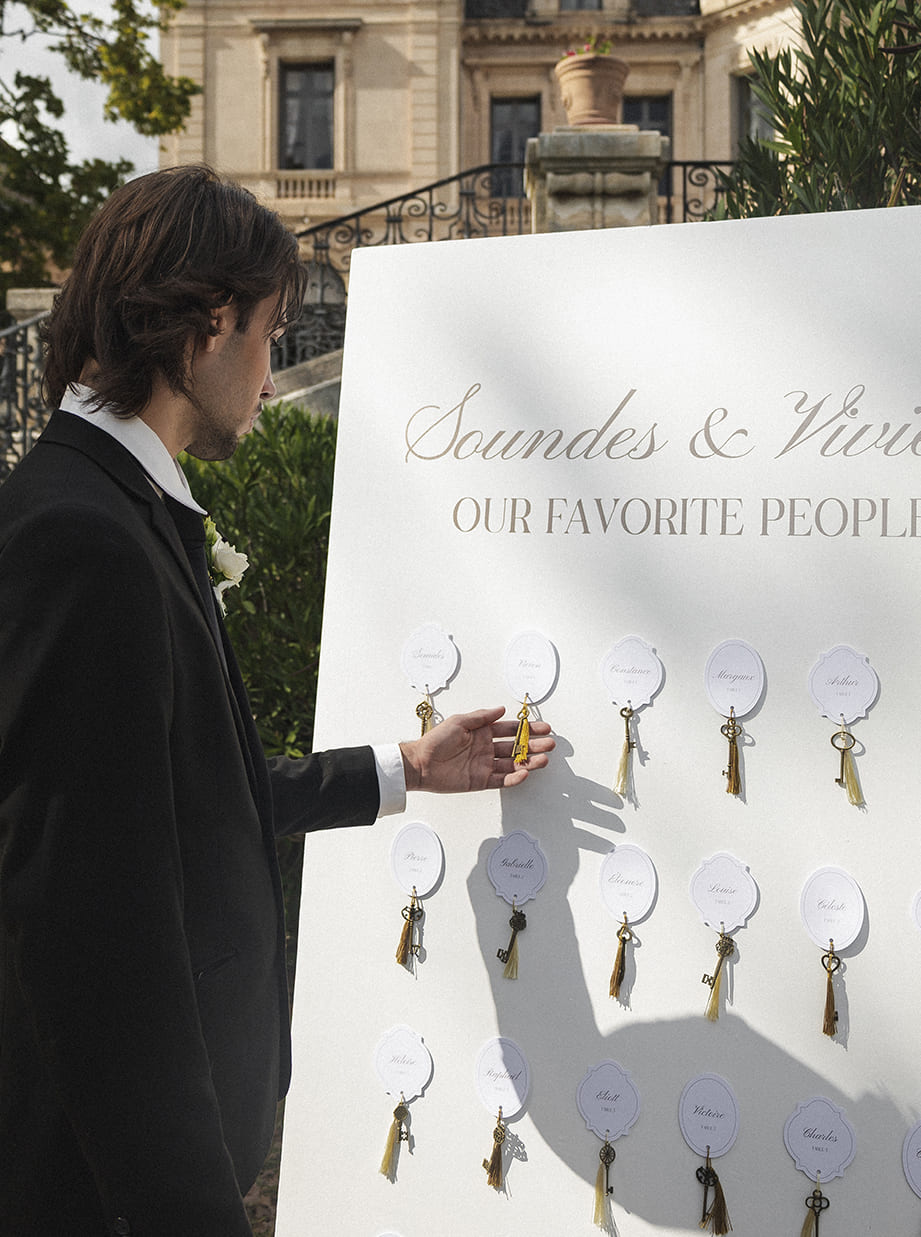 Détail du plan de table de mariage avec clés dorées sur panneau élégant au château.