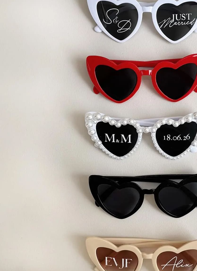 Scénographie de mariage mettant en valeur des accessoires signature lunettes en forme de coeur