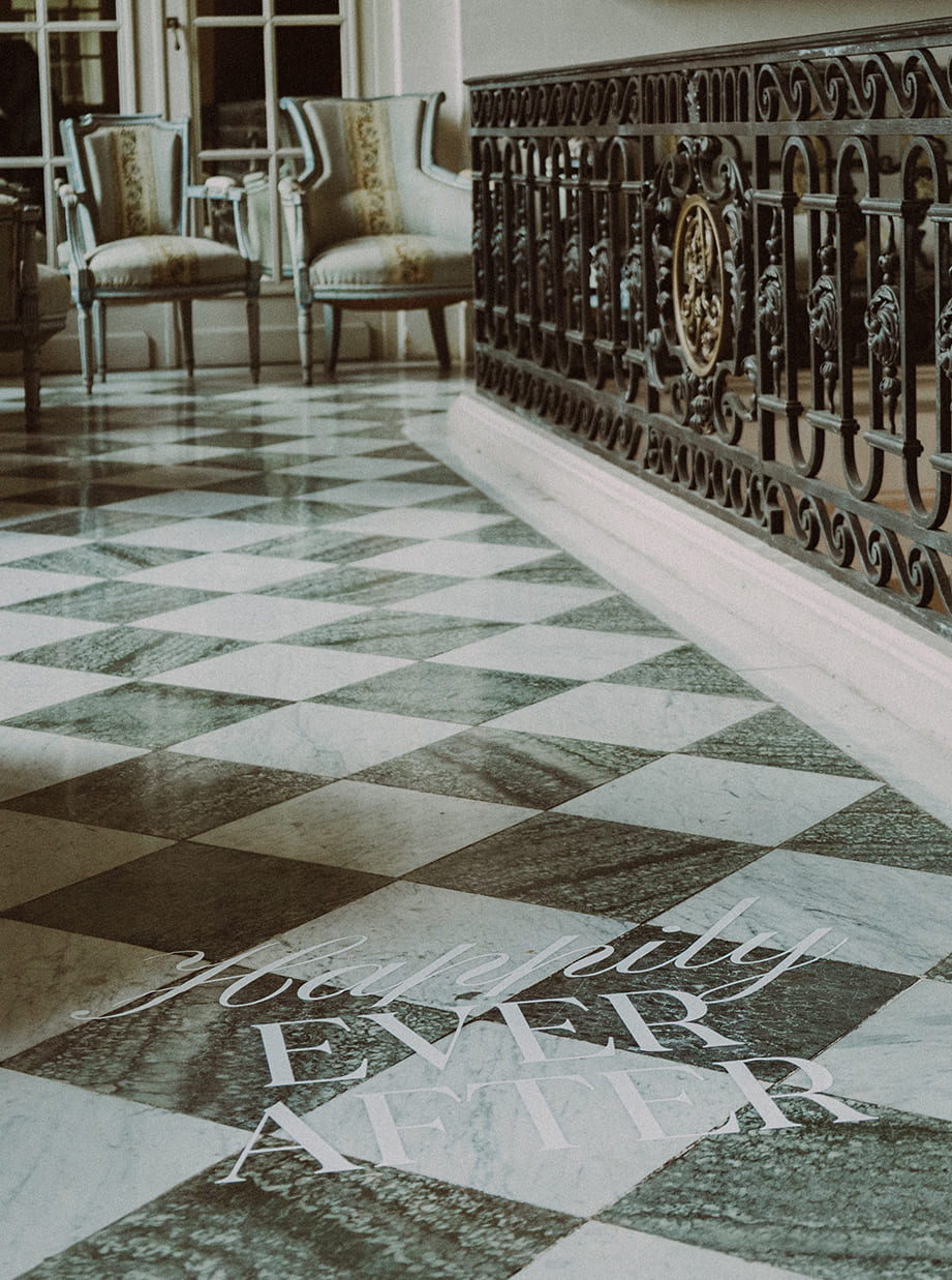 Inscription Happily ever after sur sol en damier dans un château de mariage.